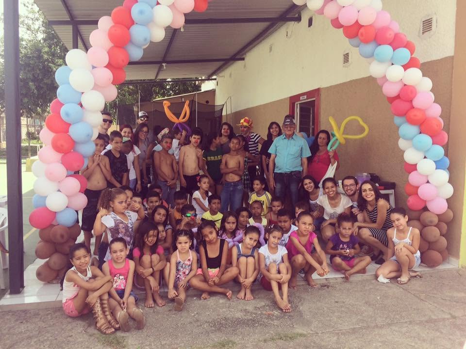 Crianças do CIS reunidas em uma festa, com arco de balões
