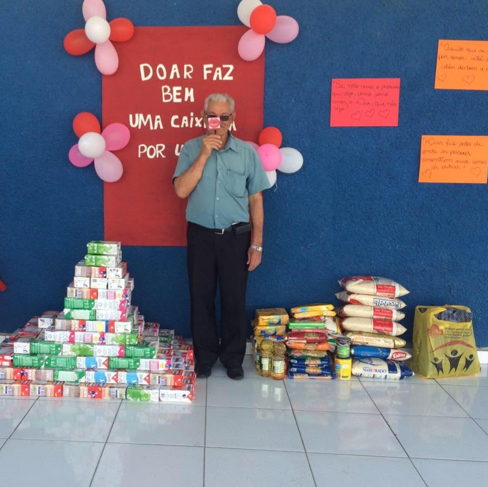 Tio Carlos ao lado dos alimentos arrecadados na campanha Doar faz bem